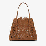 Brown perforated handbag on a white background