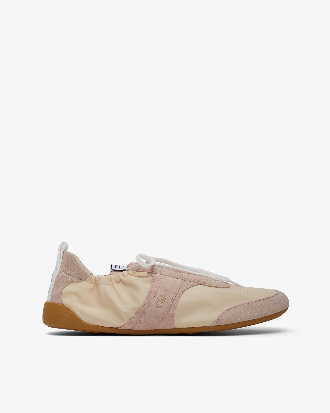 Beige slip-on shoe with a white sole on a light beige background
