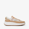 Sneaker with white sole and beige mesh upper on a white background