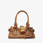 Brown handbag with gold accents on a white background