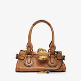 Brown handbag with gold accents on a white background