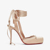 Beige high-heeled shoe with ribbon details on a white background