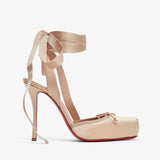 Beige high-heeled shoe with ribbon details on a white background