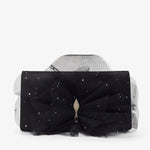 Black clutch with a large bow and star-like embellishments on a white background