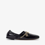 Black patent leather loafer with a gold chain on a white background