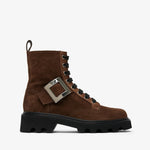 Brown suede boot with a silver buckle on a white background
